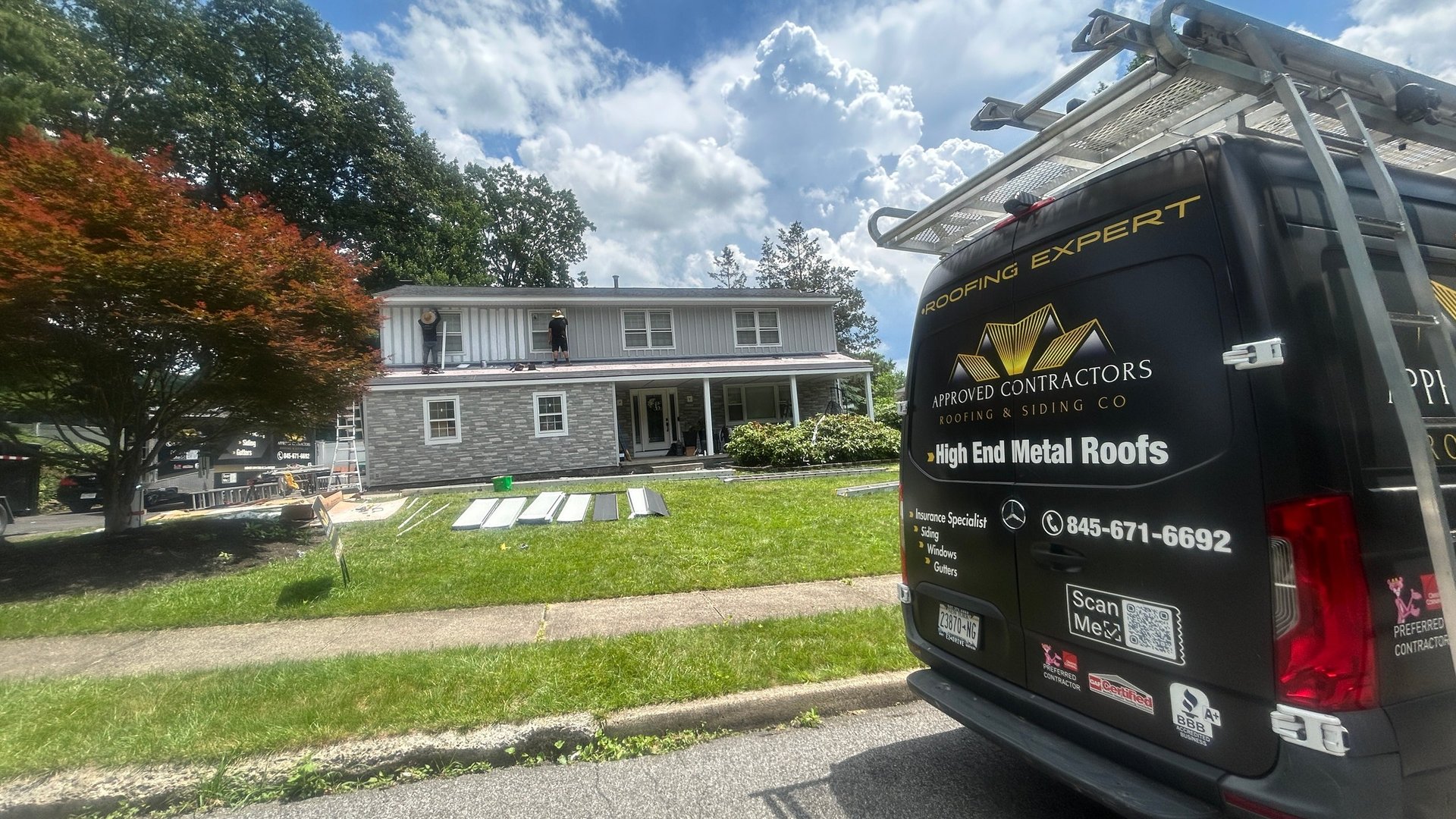 Service truck parked on residential street in front of two-story gray house with white porch