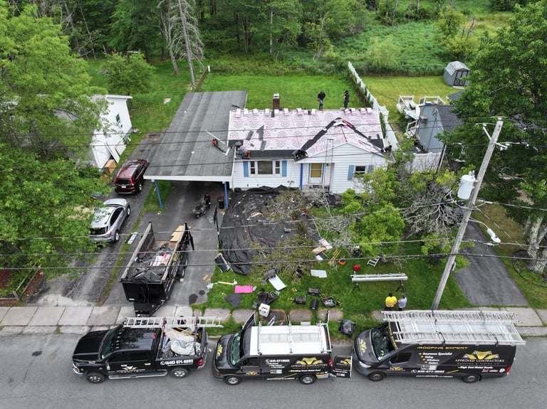 Aerial view of a residential house with multiple utility trucks parked in front on the street